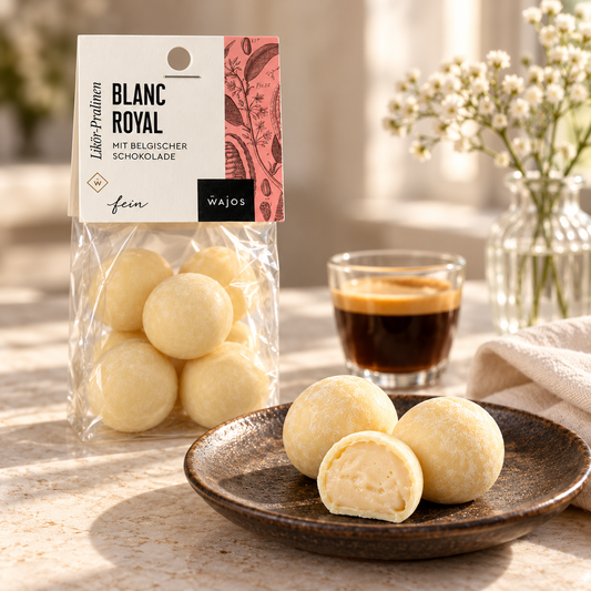 Blanc Royal Pralinen mit Anschnitt auf einem dunklen Teller zu Espresso im hellen Café-Ambiente