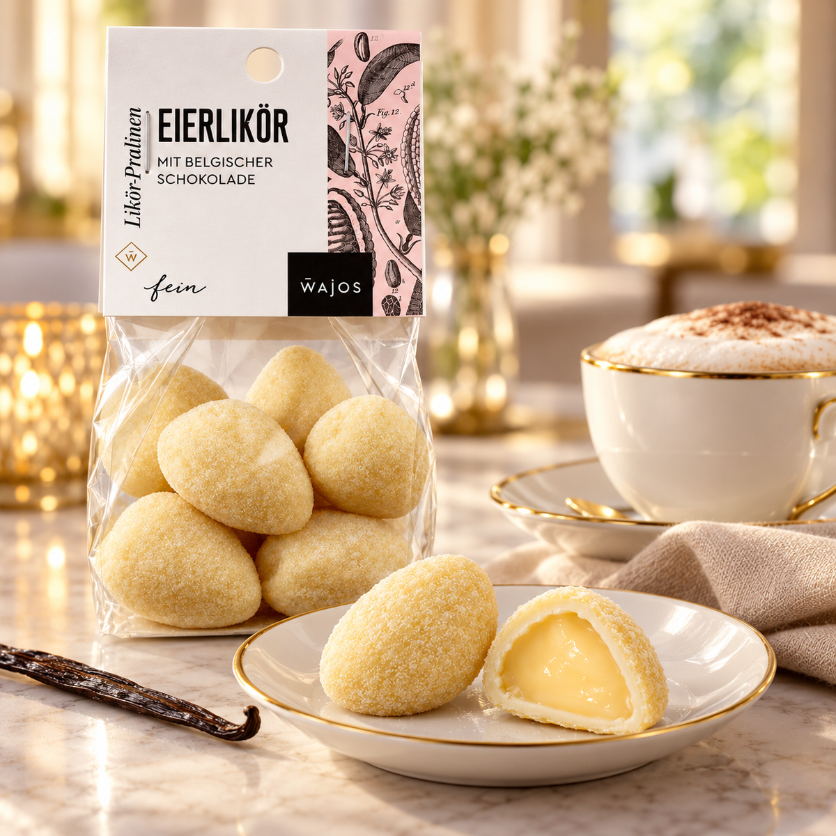 Eierlikör-Pralinen mit Anschnitt und Cappuccino auf weißem Porzellan im warmen Café-Ambiente