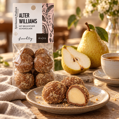 Alter Willi Pralinen mit Anschnitt, Williamsbirne und Espresso auf einem gedeckten Tisch